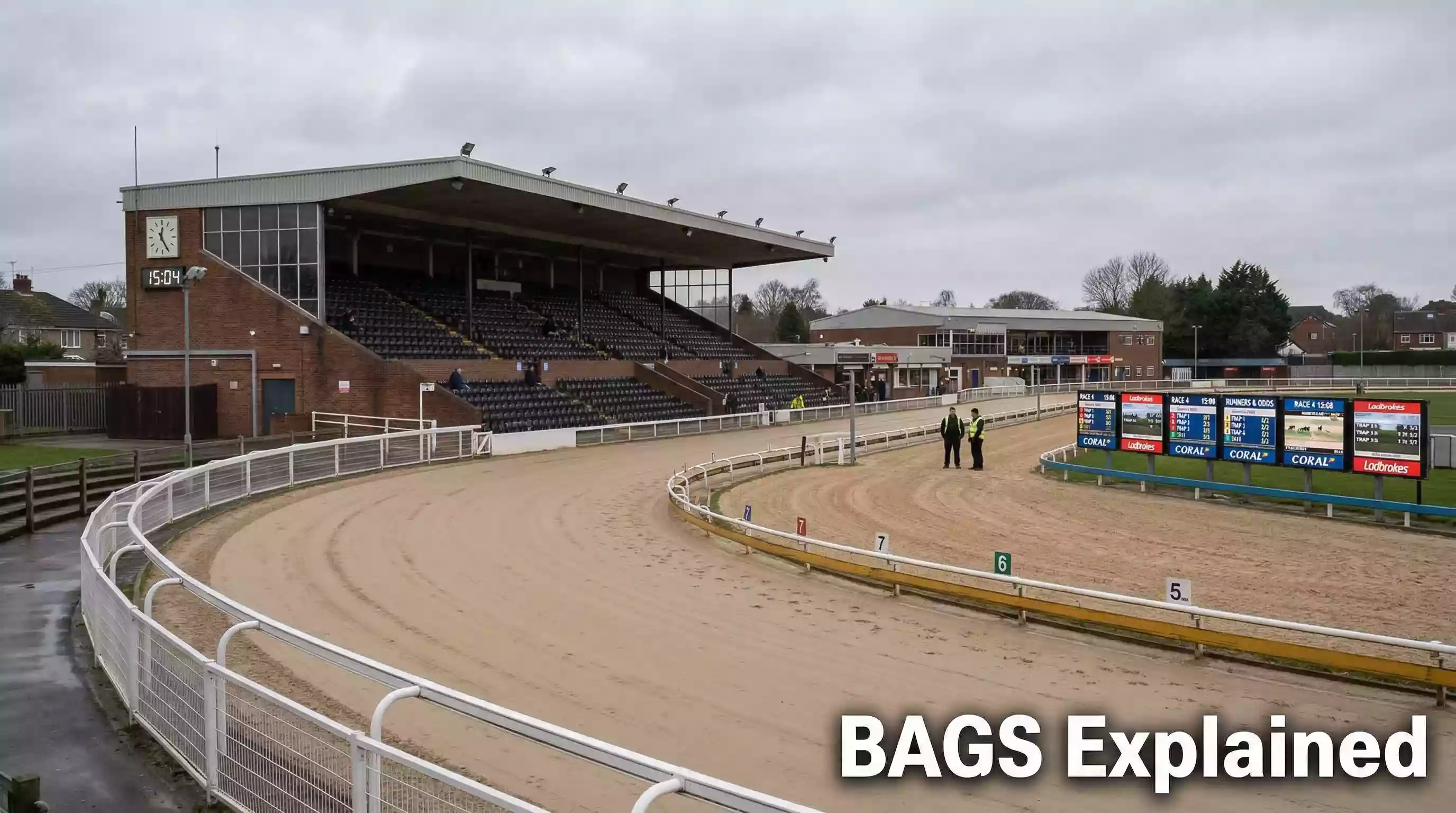 Empty greyhound track during a daytime BAGS meeting with betting screens visible