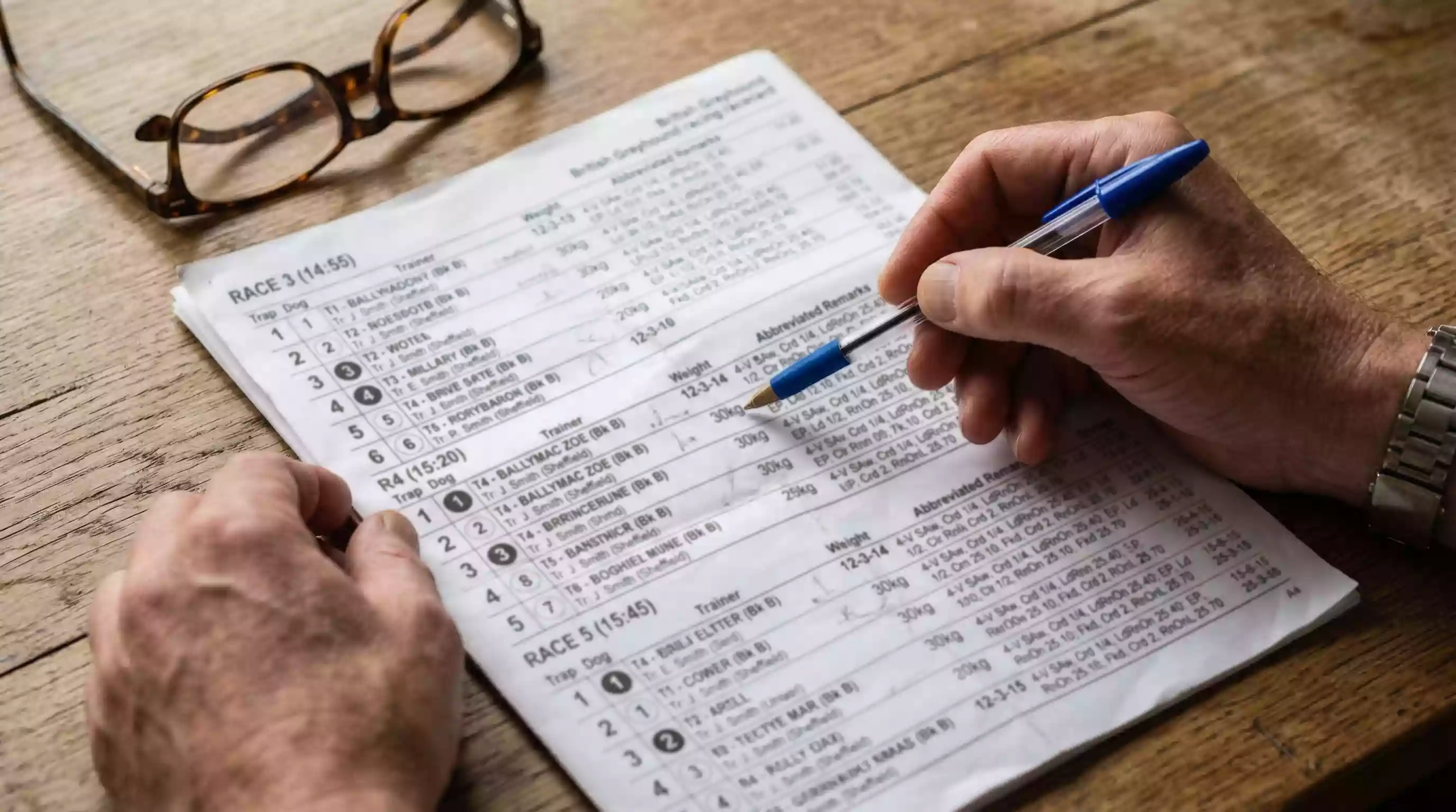 Close-up of a UK greyhound racecard showing trap numbers, in-running abbreviations and race times